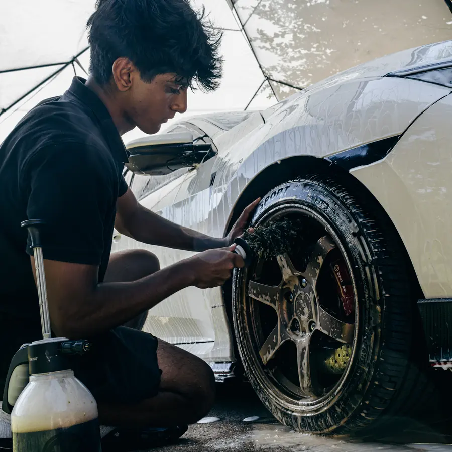 Detailer deep-cleaning a bronze wheel