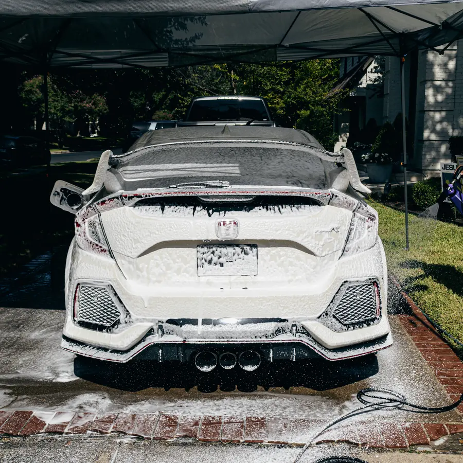 White Honda covered in foam during a hand wash