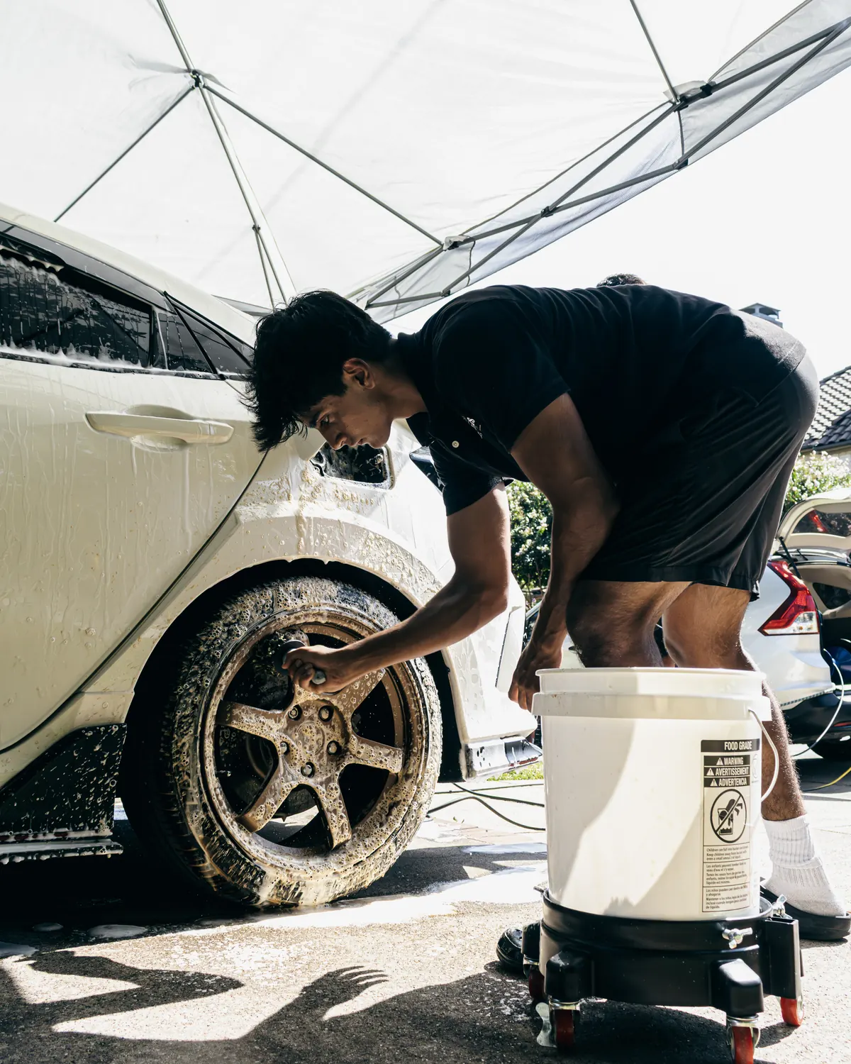 Forever Fresh detailer deep-cleaning a wheel in a McKinney driveway